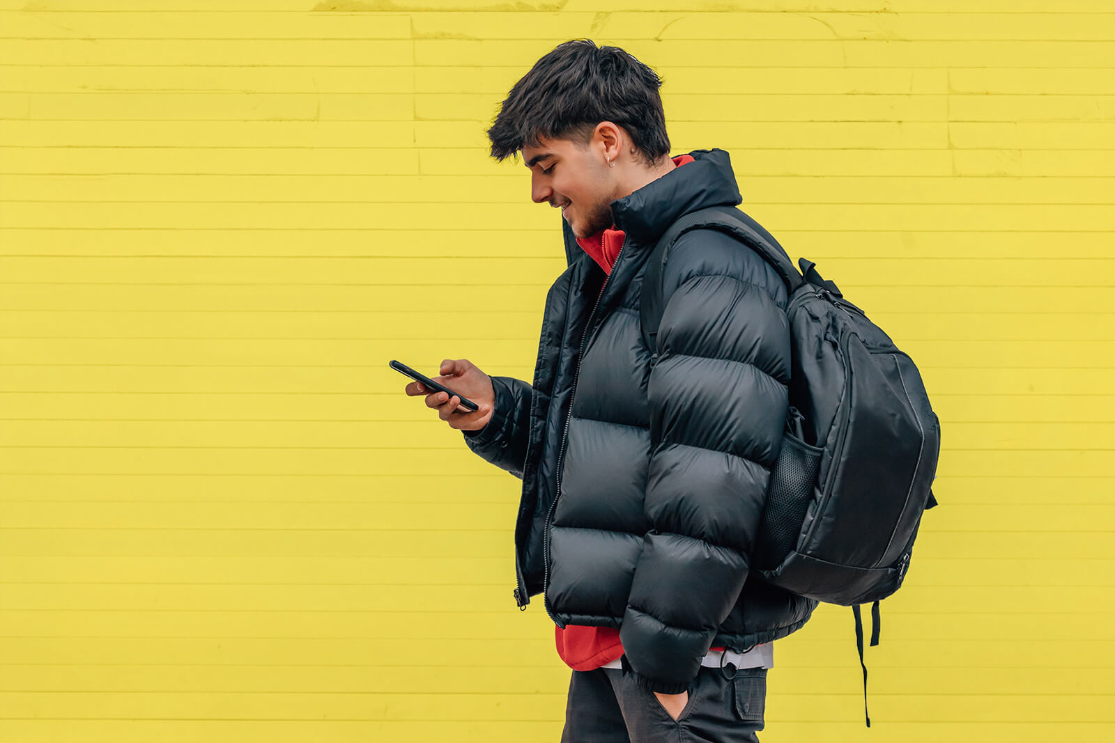 A young man comares costs of colleges using his smart phone